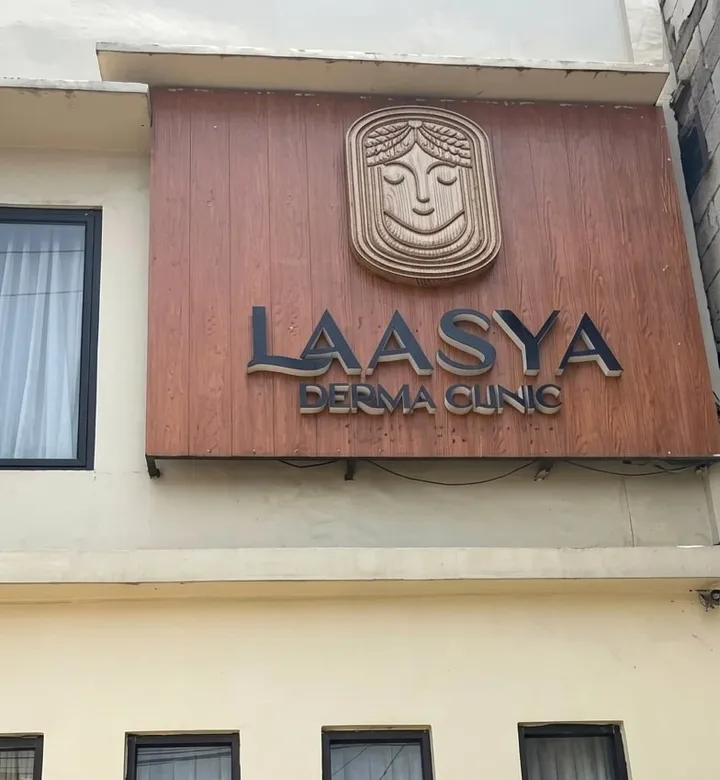Papan nama kayu Laasya Derma Clinic di bagian depan bangunan